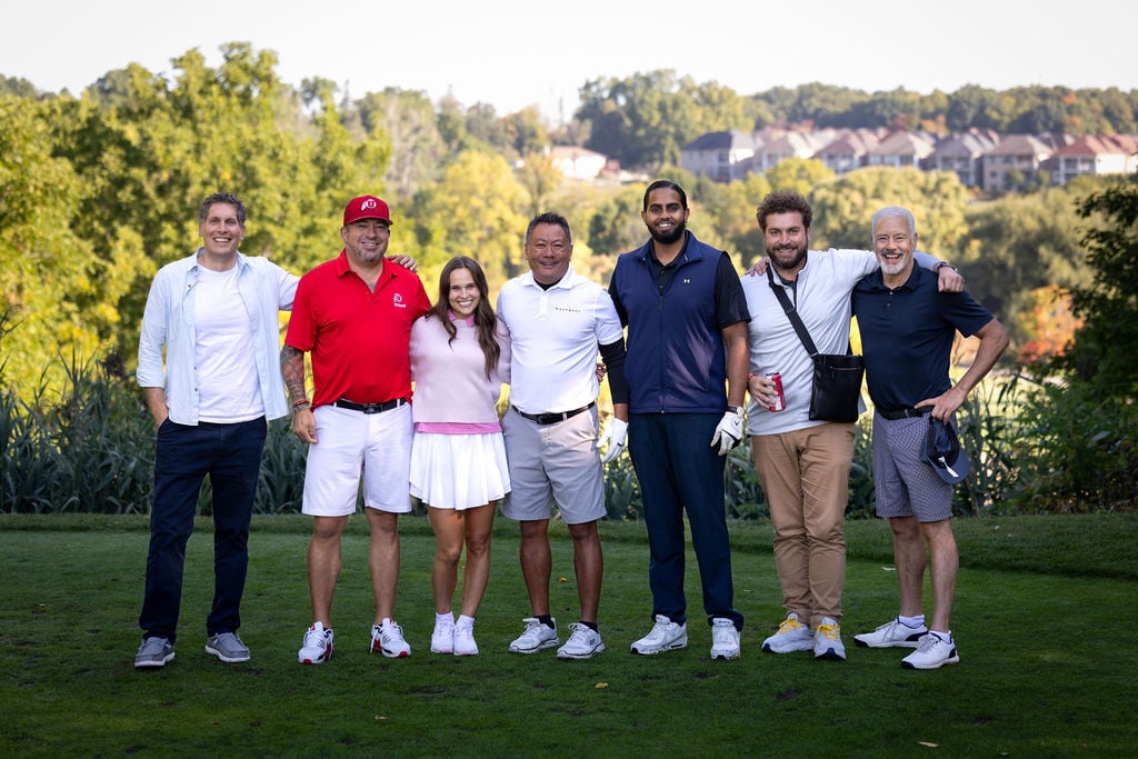 Seven golfers pose together on the course during the IGNITE 25 golf tournament, part of Techdinamics' 2025 user conference in Toronto.