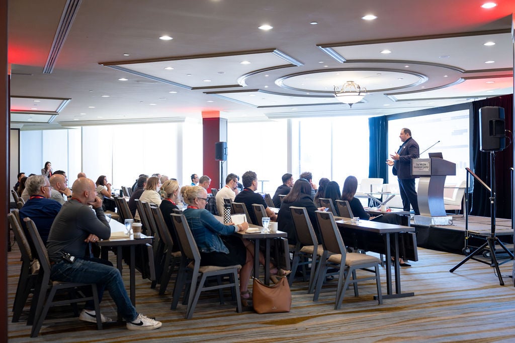 Speaker presenting to attendees during an IGNITE 25 conference session