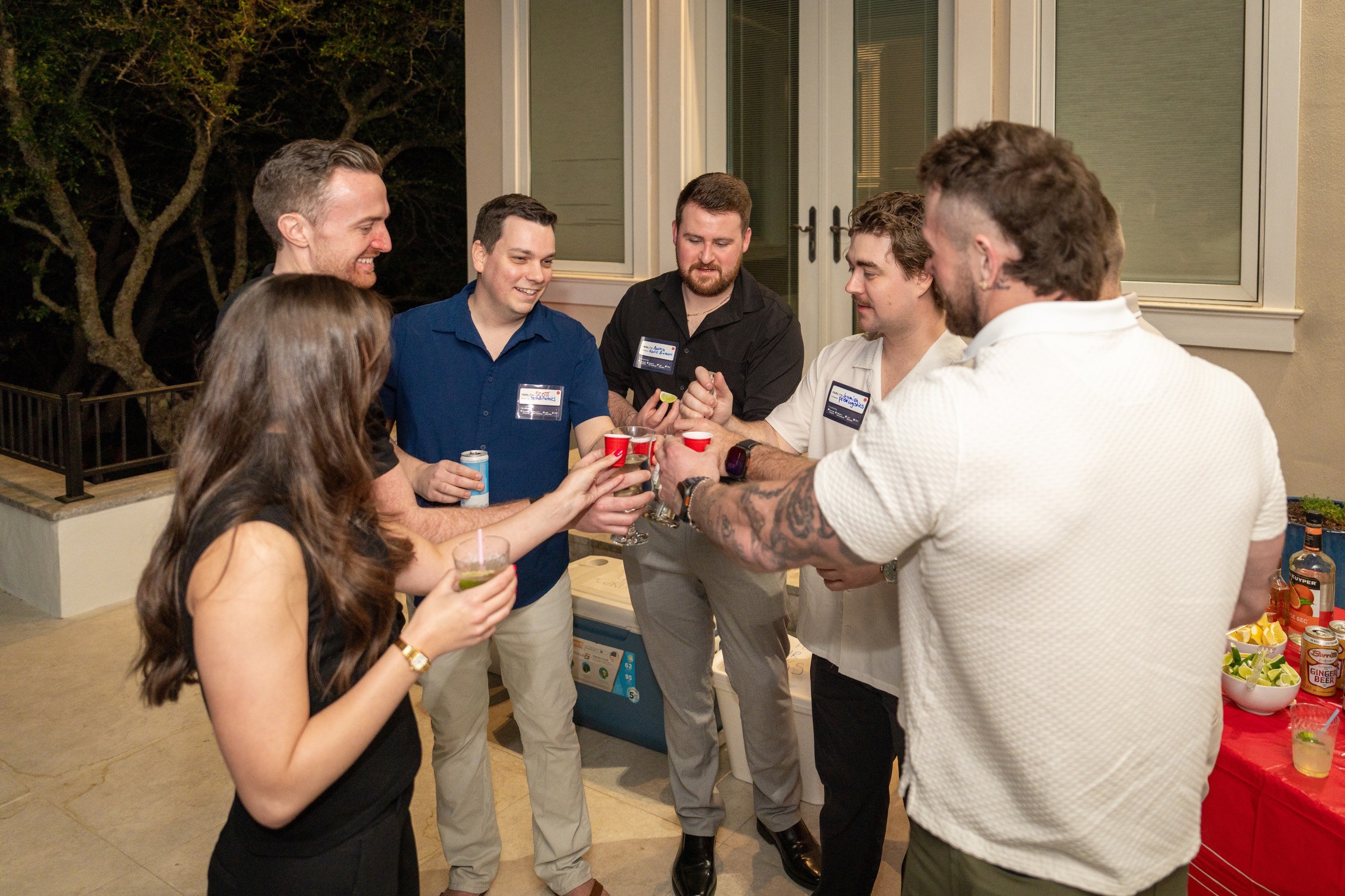Five male guests and one woman toasting