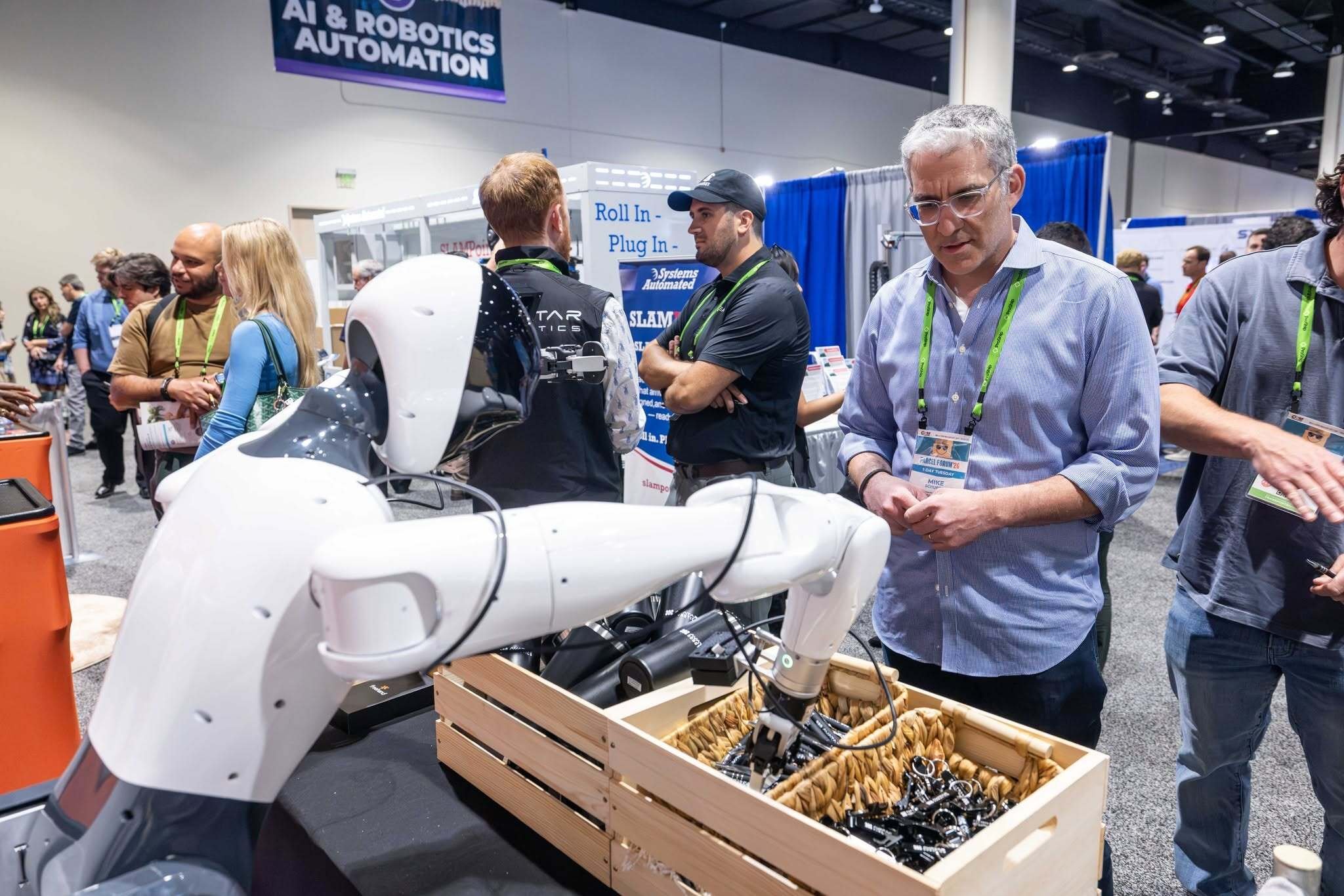 A PARCEL Forum ’26 attendee watches a robotic automation demonstration on the expo floor.