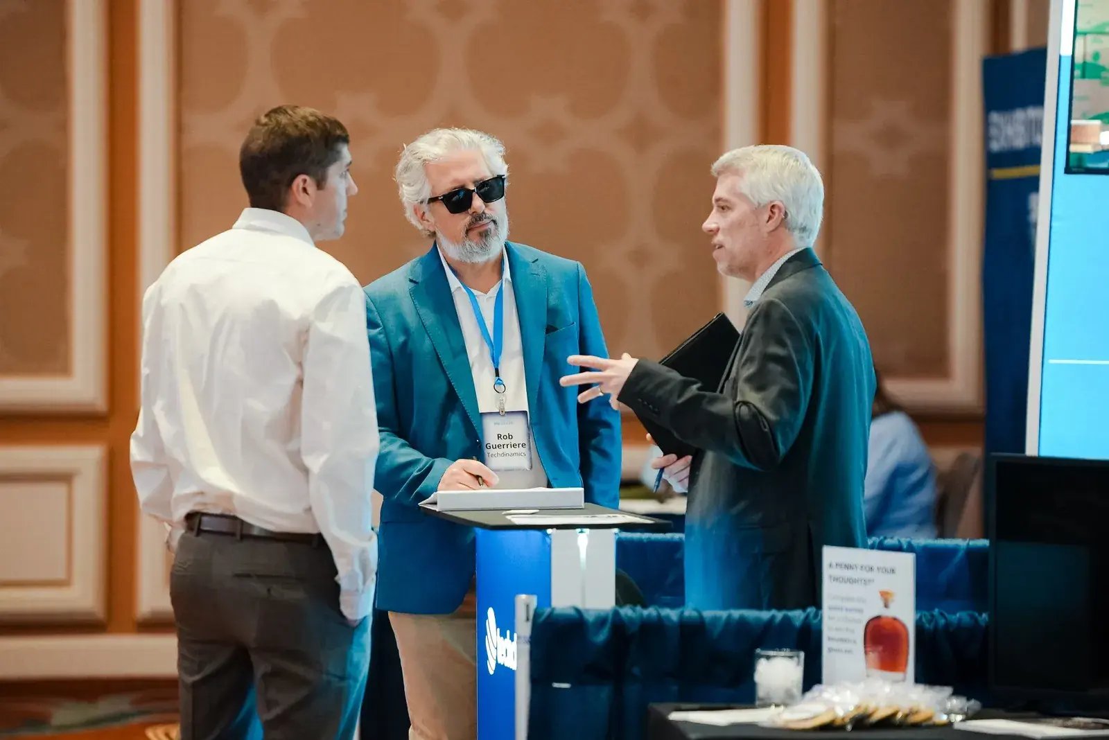 Techdinamics representatives discussing shipping and supply chain solutions with conference attendees at an industry expo.
