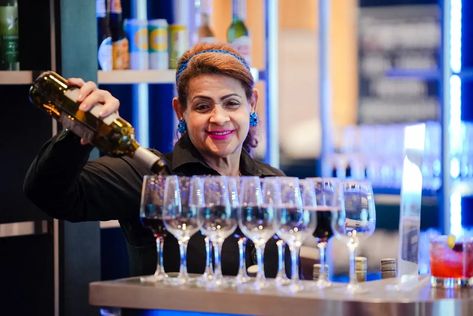 A woman bartender serving wine during networking activities at the American Supply Chain Summit event.