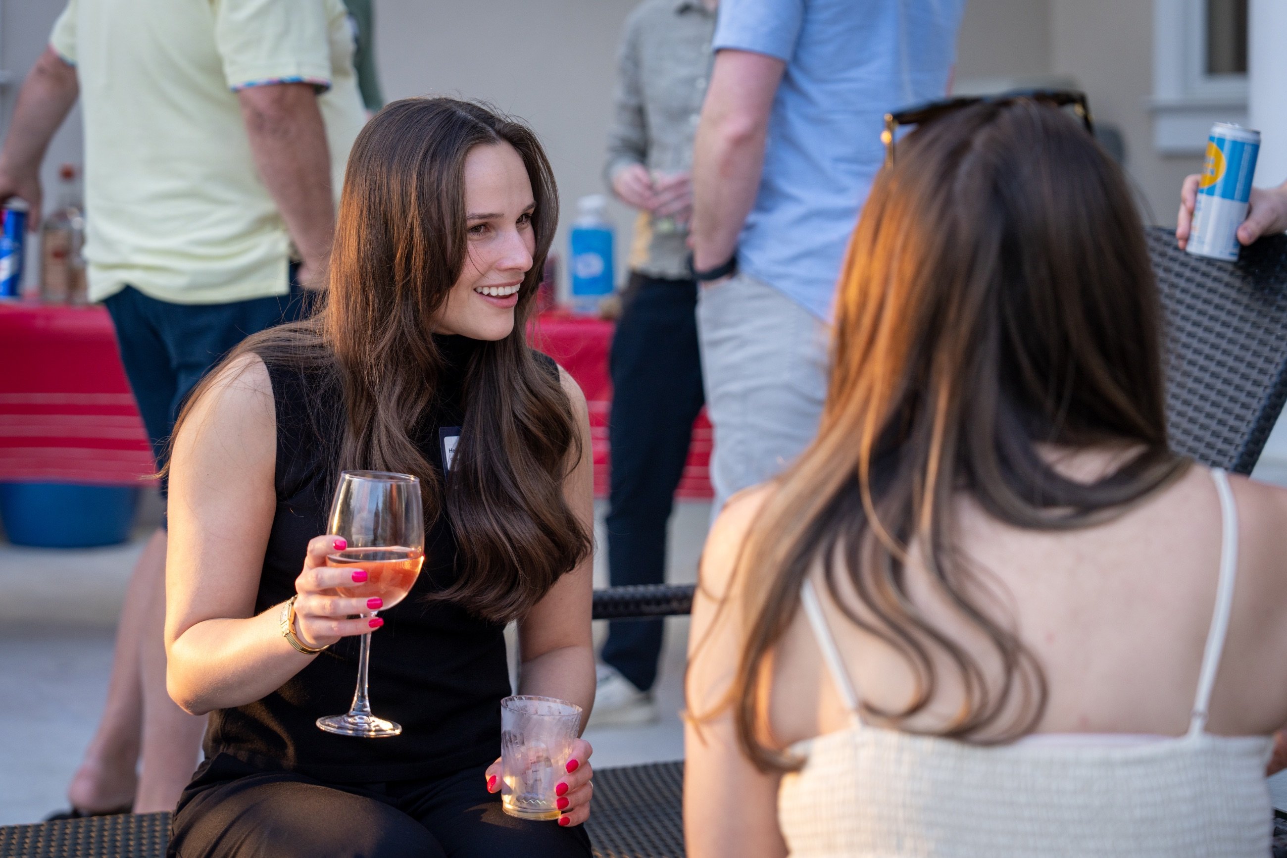 A girl holding a cocktail and chatting