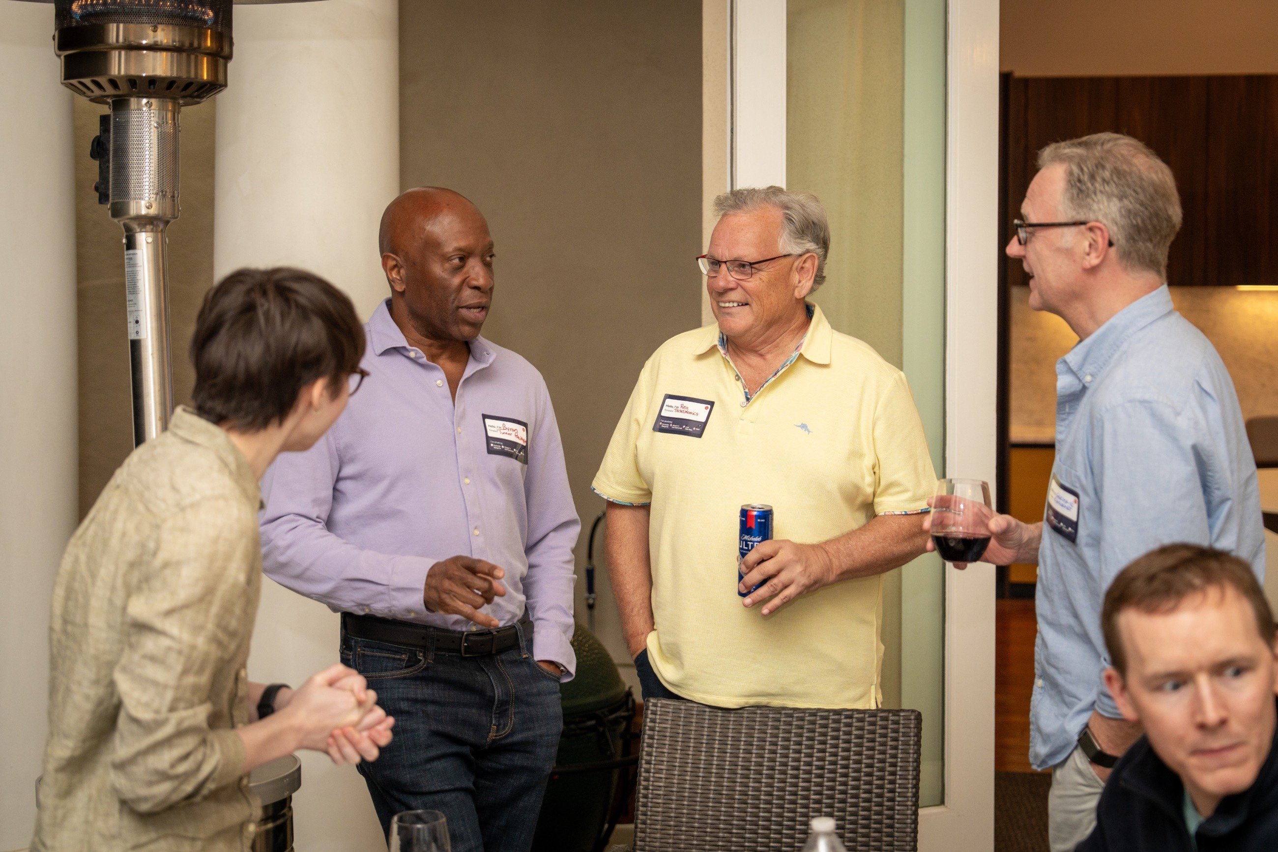 Four guests chatting at the party and drinking.