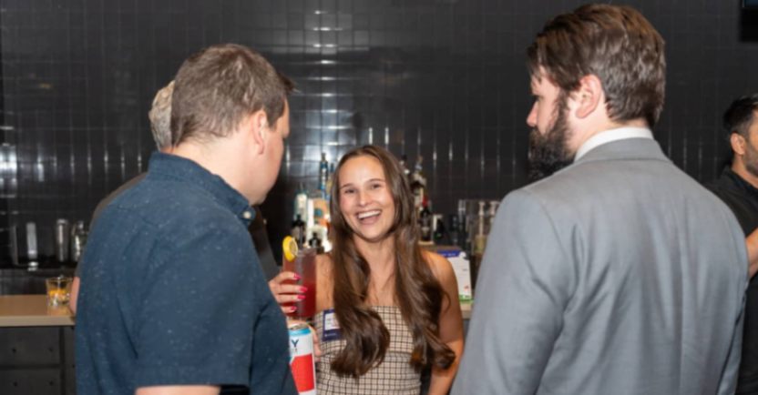 Attendees chatting and networking in a lounge area during an industry gathering.