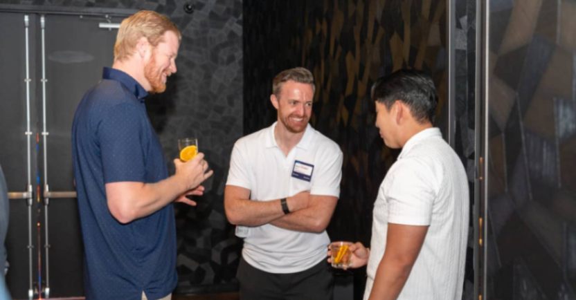 Attendees chatting and networking in a lounge area during an industry gathering.