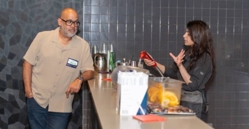 Guest ordering a drink at the event bar during a networking reception.