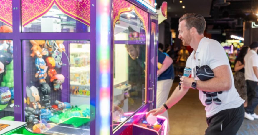Event attendees posing with arcade prizes at a networking and entertainment venue.