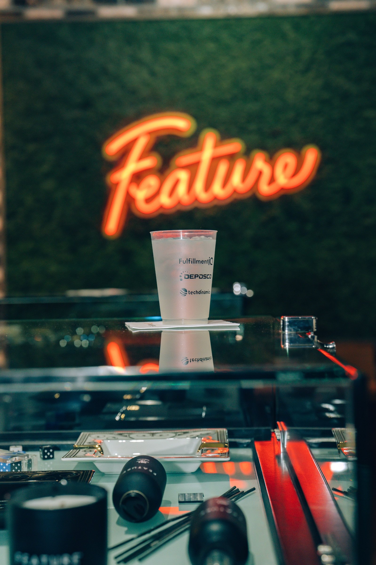 A glass featuring the logos of all 3 hosts